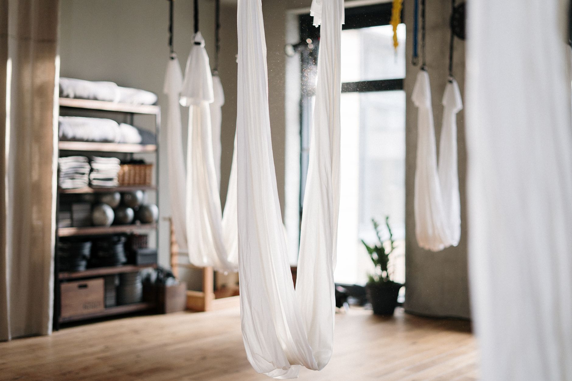A peaceful yoga studio featuring aerial yoga hammocks for fitness and relaxation.